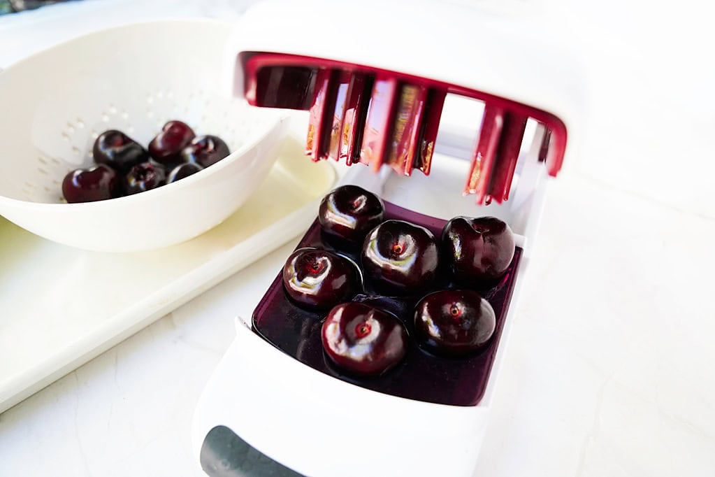 cherry pitter with cherries in it