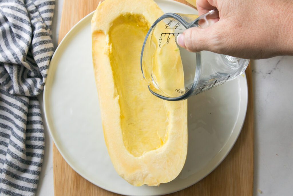 placing water in hollowed half of squash