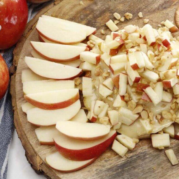 Overhead photo of a wooden board with apple walnut baked brie