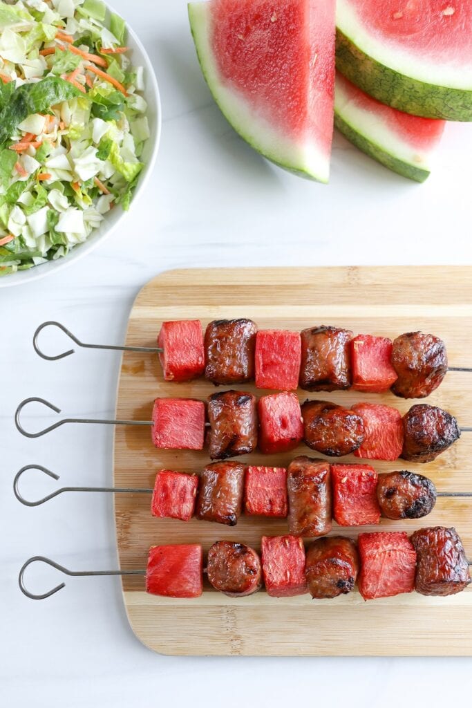 watermelon sausage kabobs on a wooden board