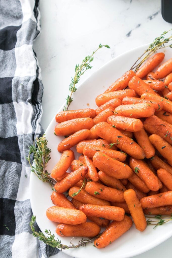 vertical shot of brown sugar and cinnamon carrots on white plate