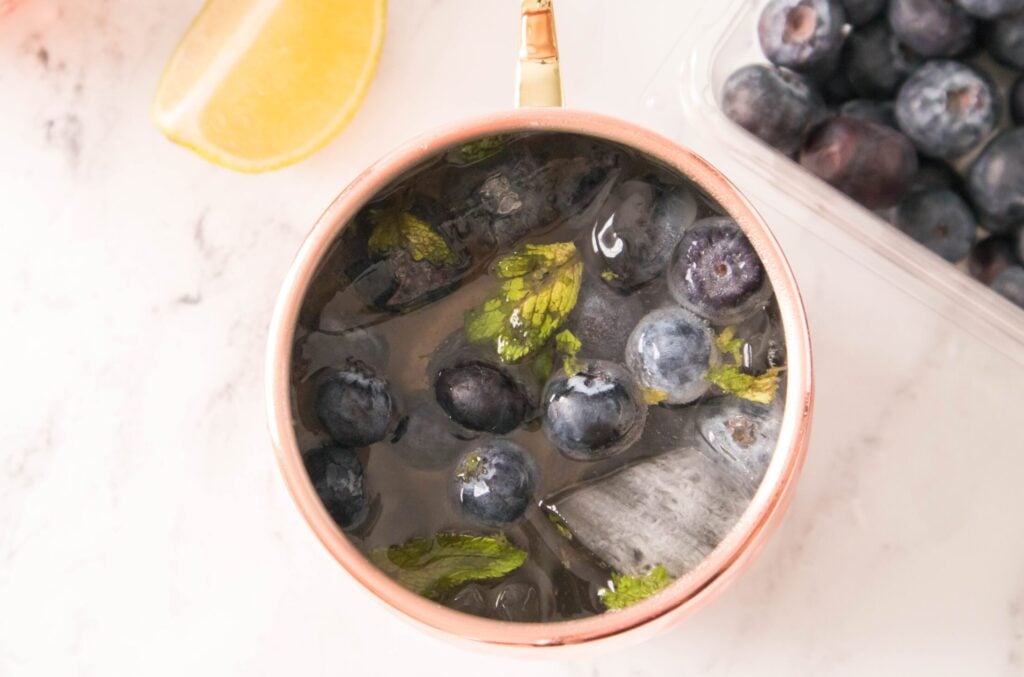 overhead horizontal shot of a blueberry moscow mule drink