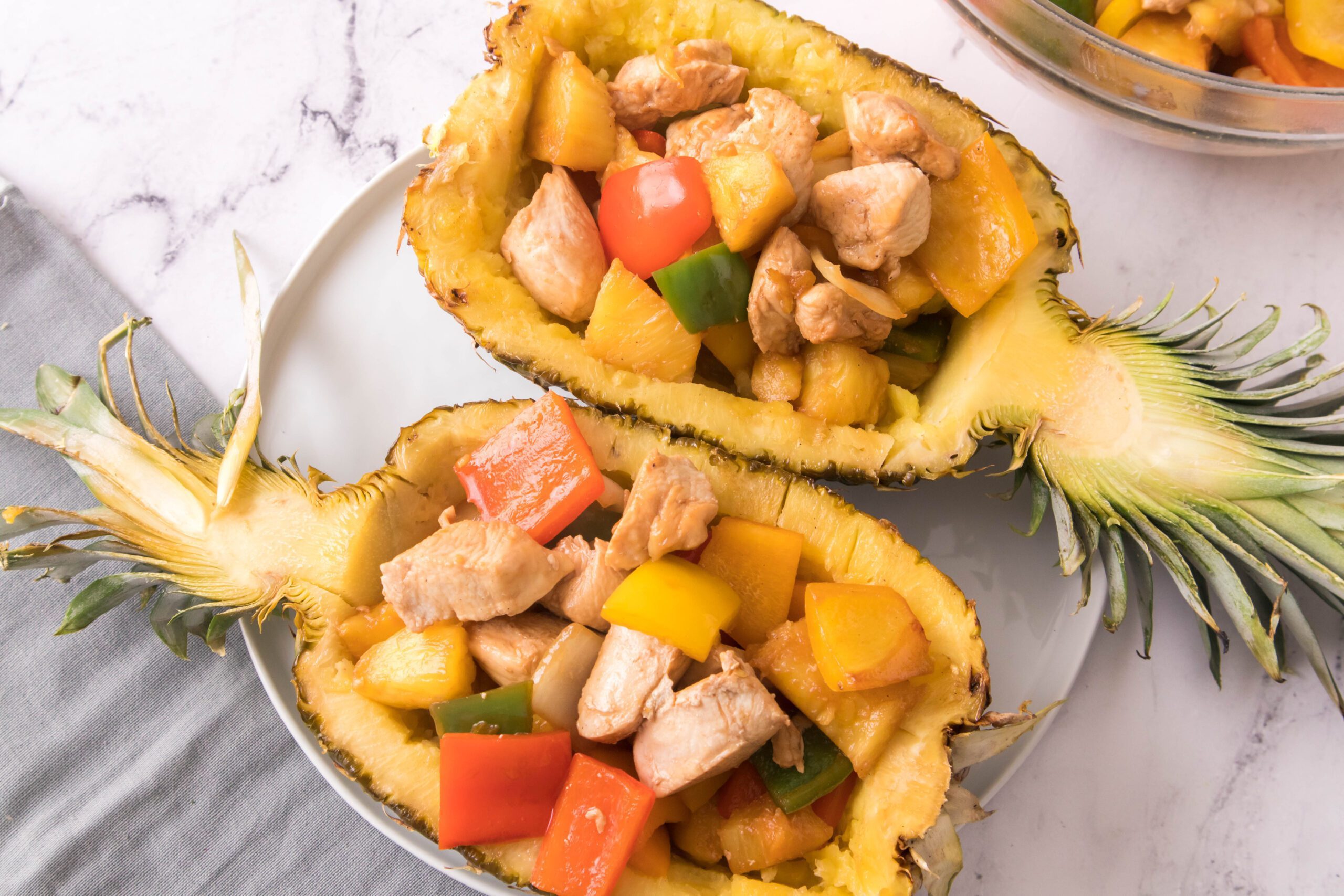 Two Pineapple Bowls filled with chicken and veggies