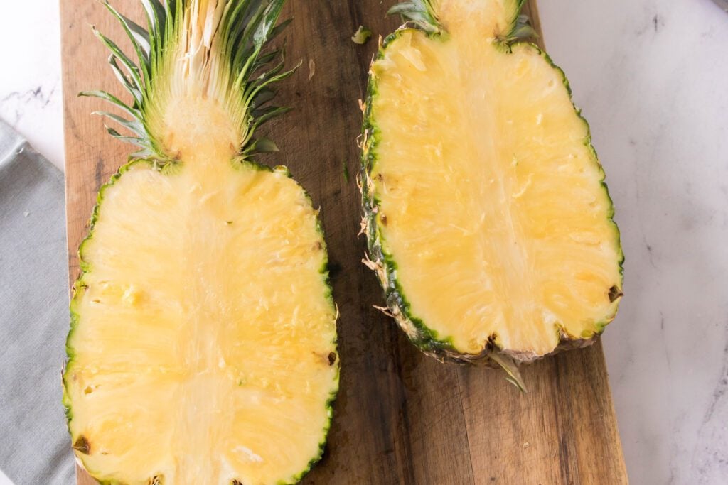 Two halves of a pineapple showing the pineapple flesh inside