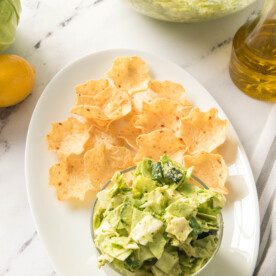 overhead shot of greek goddess salad on a serving platter with tortilla chips