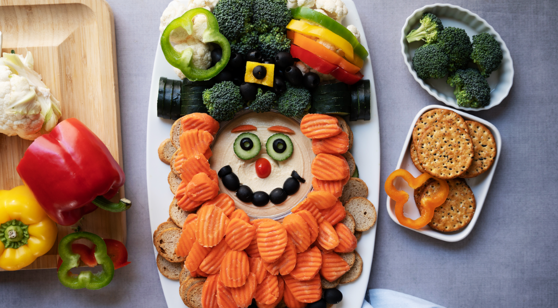 Tray of vegetables: bell peppers, broccoli, cauliflower, bell peppers, black olives, carrot chips