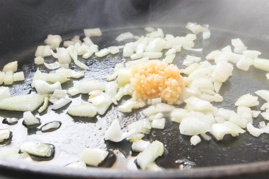 Adding garlic to the onion and olive oil mixture