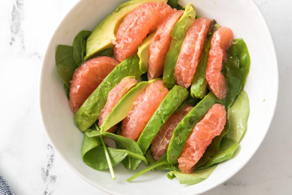 grapefruit and avocado slices layered on spinach base