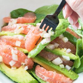 fork with avocado and grapefruit in white bowl