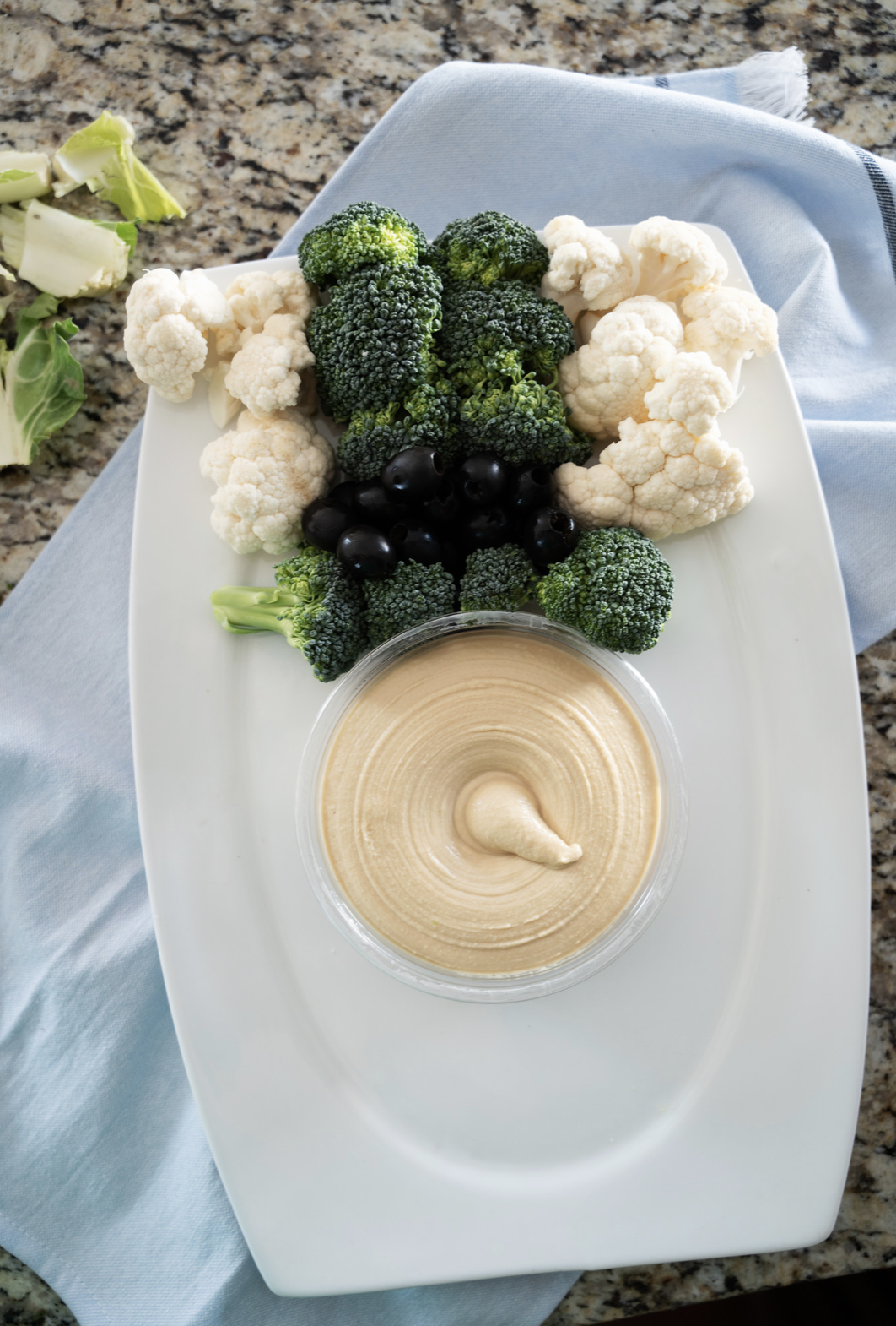 Hummus has Face and build out of hat with broccoli and cauliflower