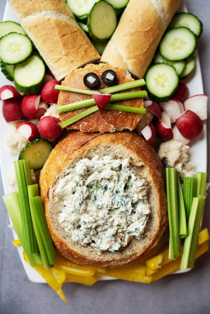 vertical image of spinach artichoke bread bowl bunny inspired
