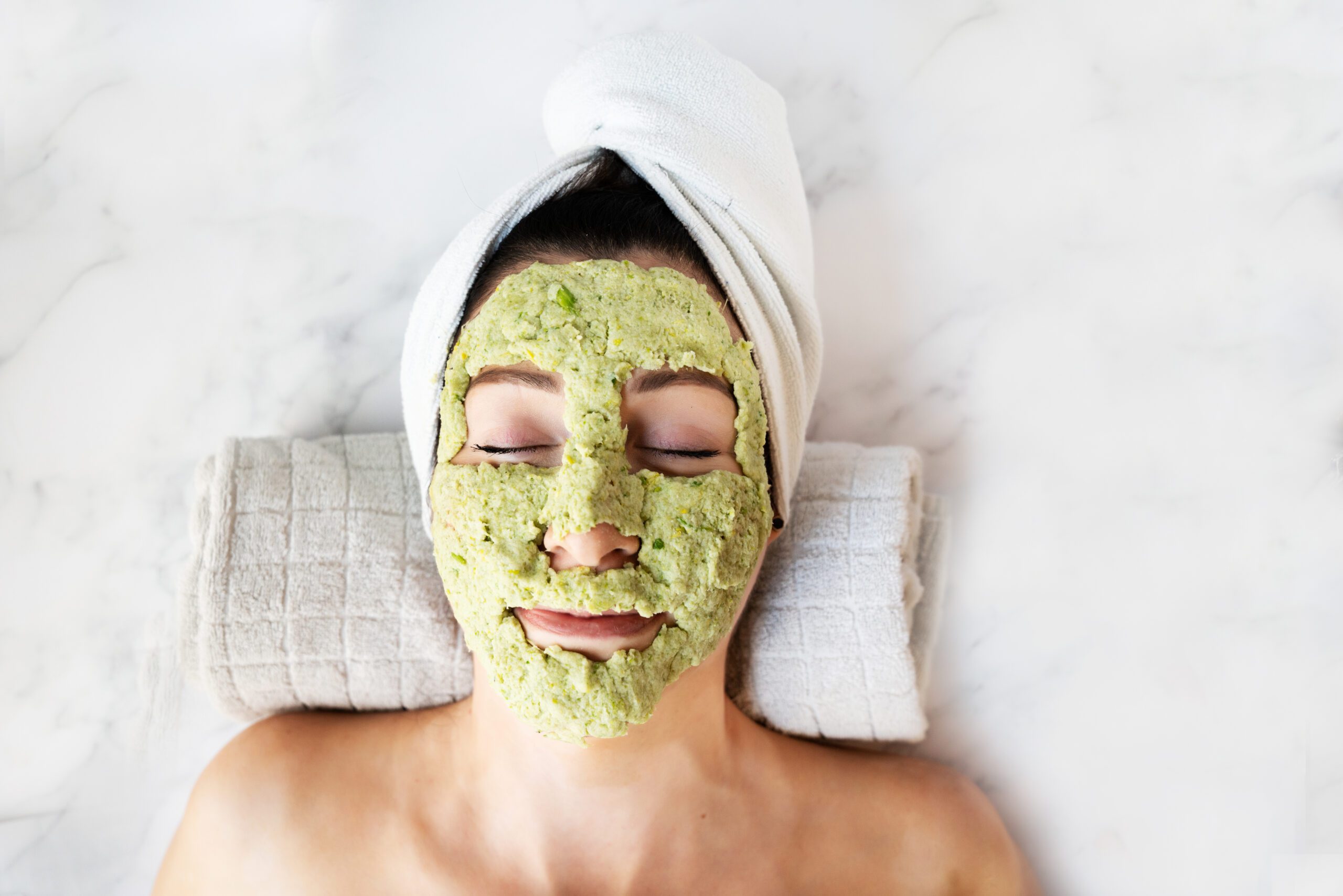 Woman laying down with celery face mask 