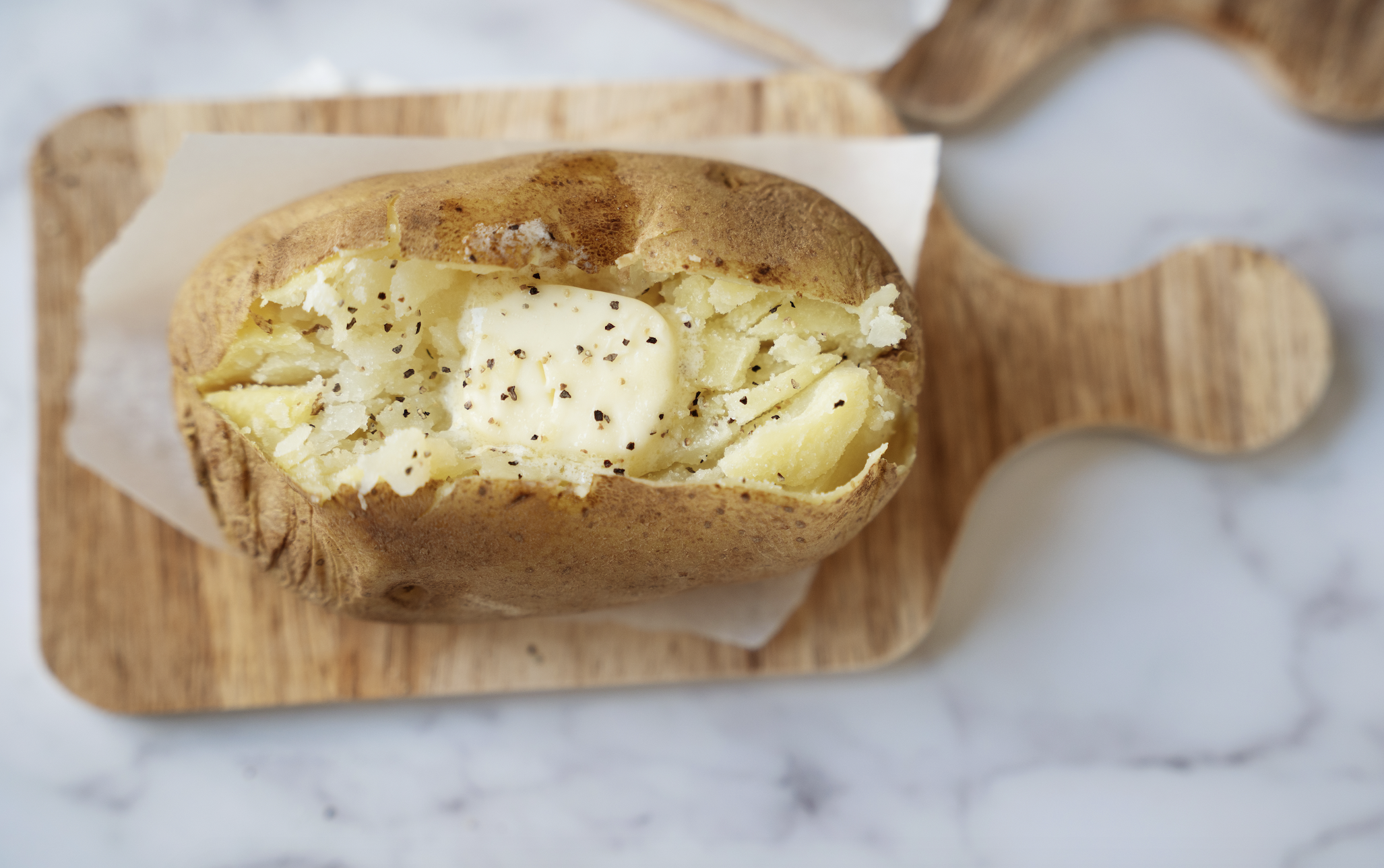 Open baked potato with butter and salt and pepper