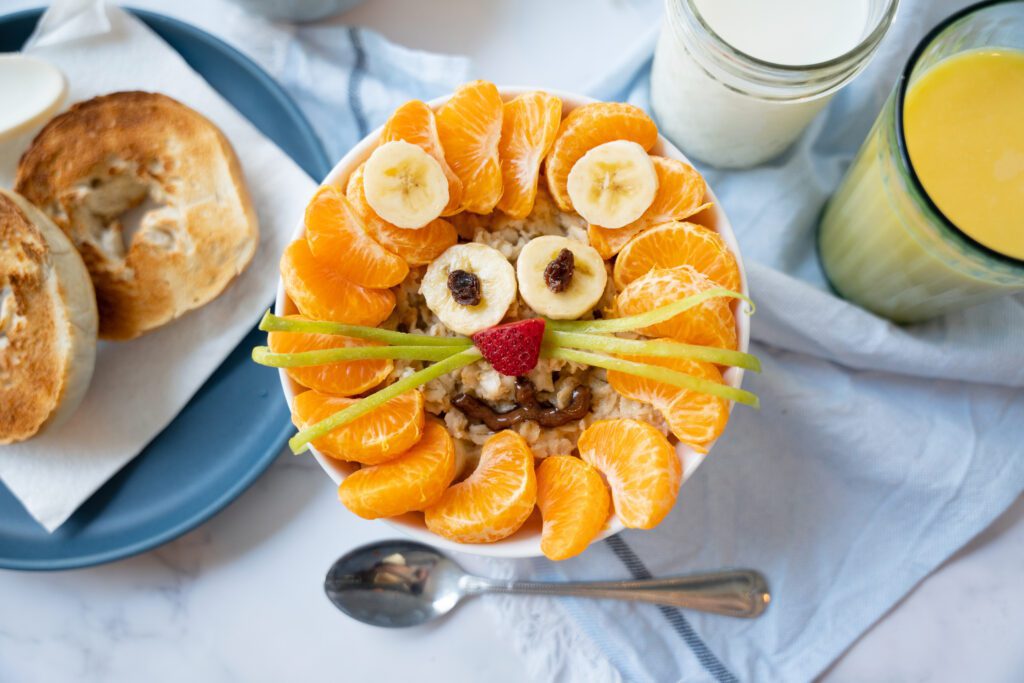 oatmeal with a lion made from oranges and bananas to help learn How to Get Kids to Eat Healthy