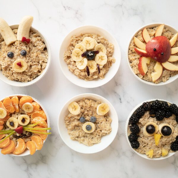 6 bowls of oatmeal with animals made from fruit