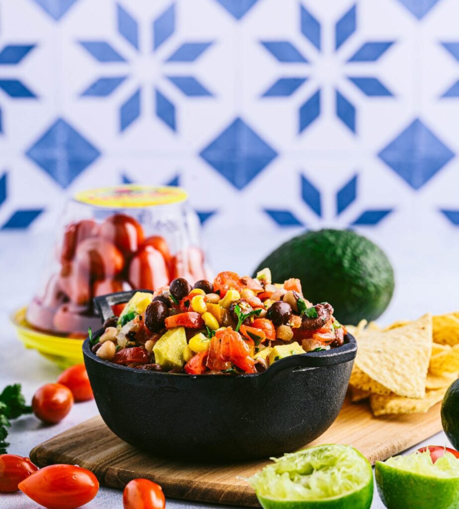 cowboy caviar surrounds by grape tomatoes, avocado, lime sand chips