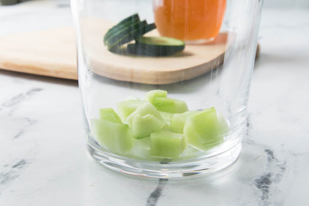 diced cucumbers at the bottom of a glass
