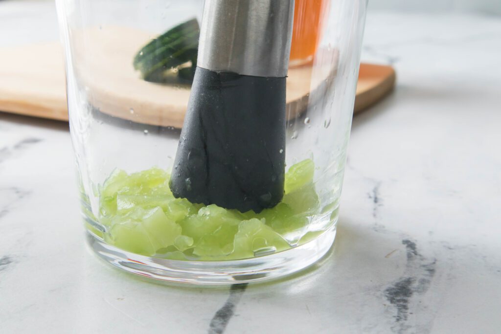 Muddling cucumbers in glass