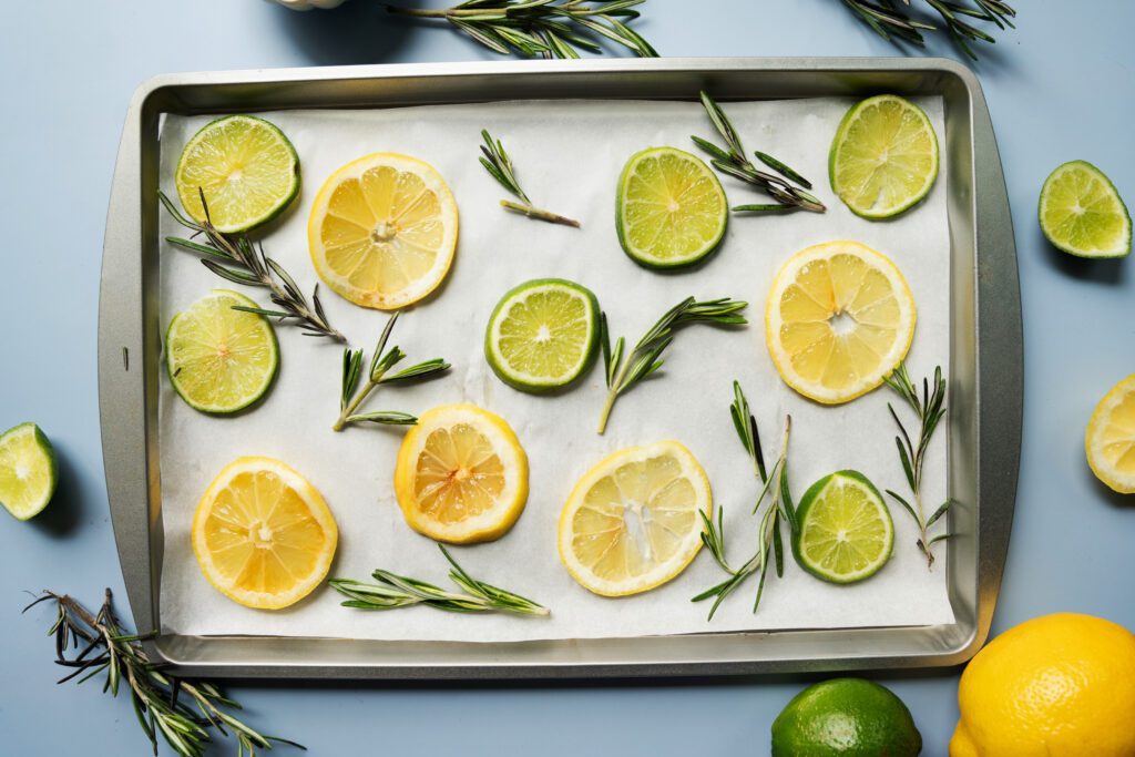 lemon, limes and rosemary on a baking sheet
