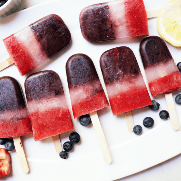 overhead shot of red white and blue popsicles on white serving tray