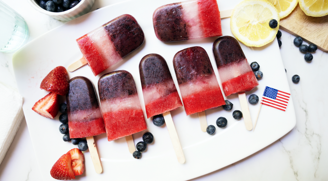 overhead shot of red white and blue popsicles on white serving tray