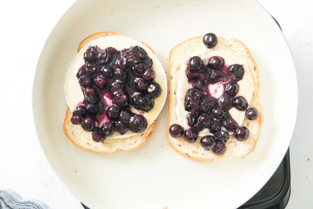 Open face sandwich with brie cheese and blueberries in grill pan