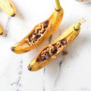 banana topped with nut butter, dark chocolate chips and walnuts