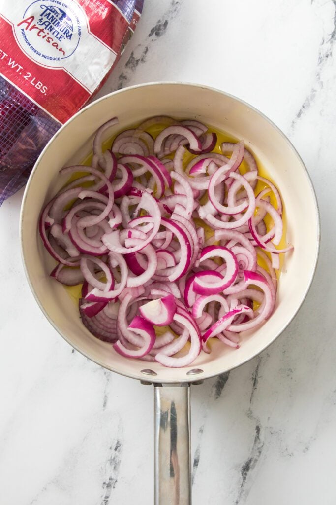sliced onions in saucepan with olive oil