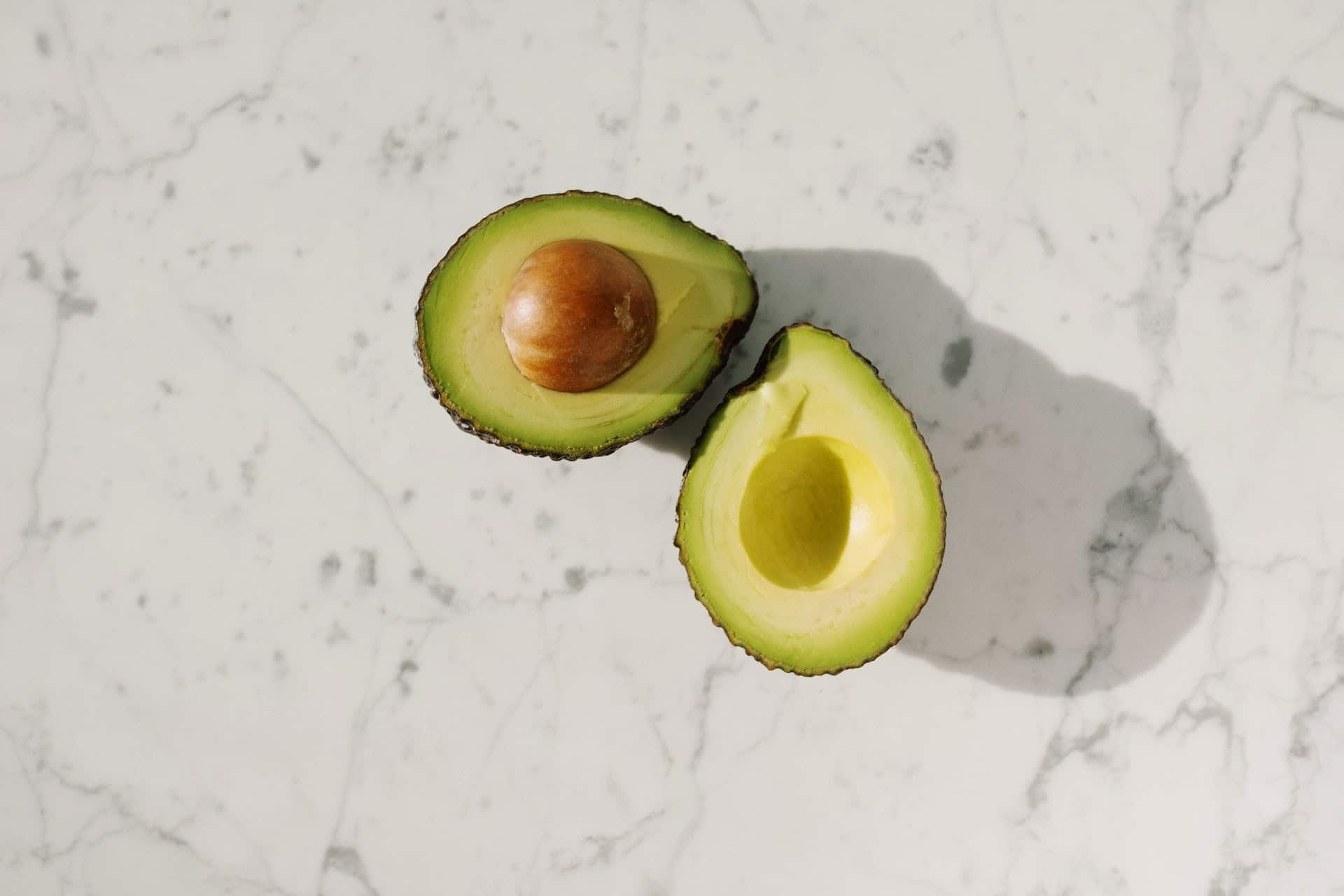 avocado sliced in half with the pit