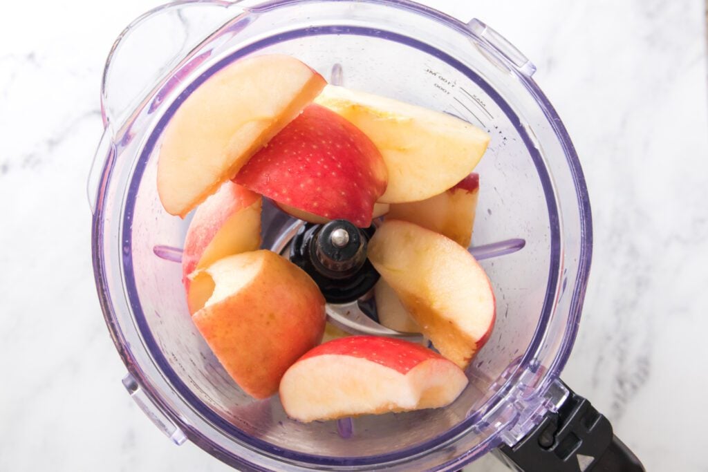 overhead shot of apples in blender with water