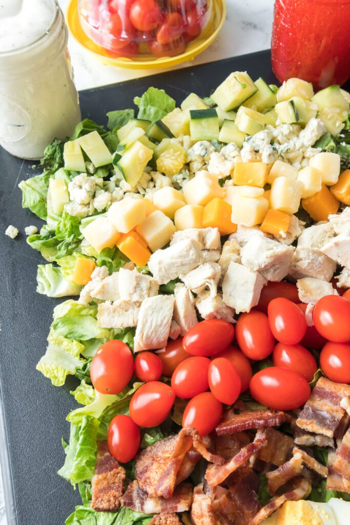 close up of ingredients layered on serving platter for cobb salad recipe