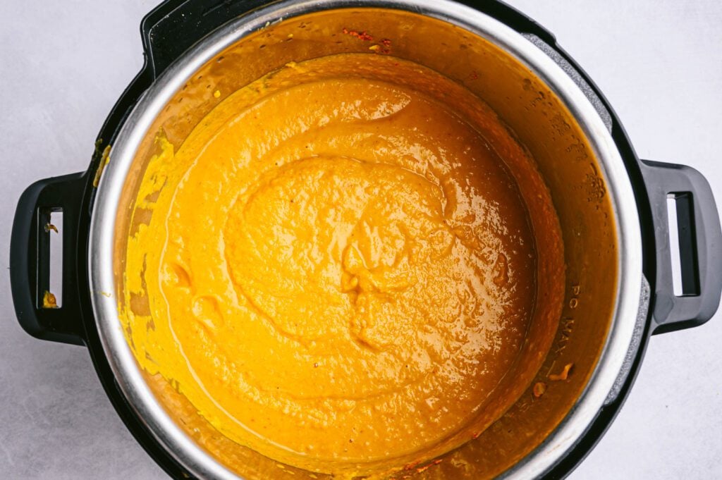 Add coconut milk, peanut butter, leftover curry paste, and 2 1/2 cups of water to your slow cooker and stir until melted and combined. Blend with an immersion blender until creamy.