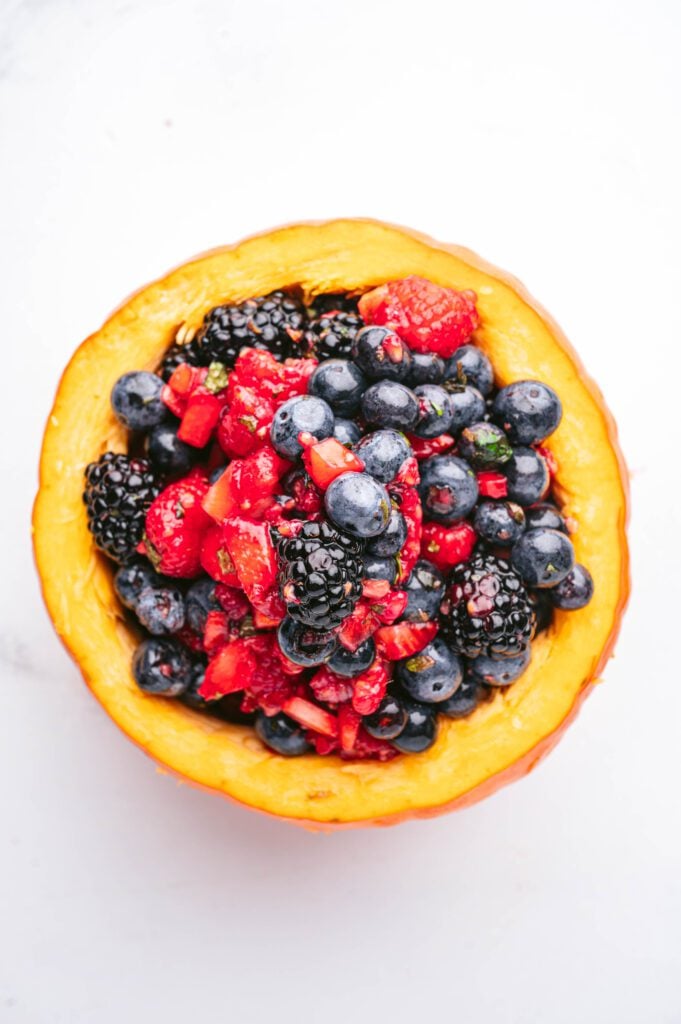 berry fruit salad served inside mini pumpkins