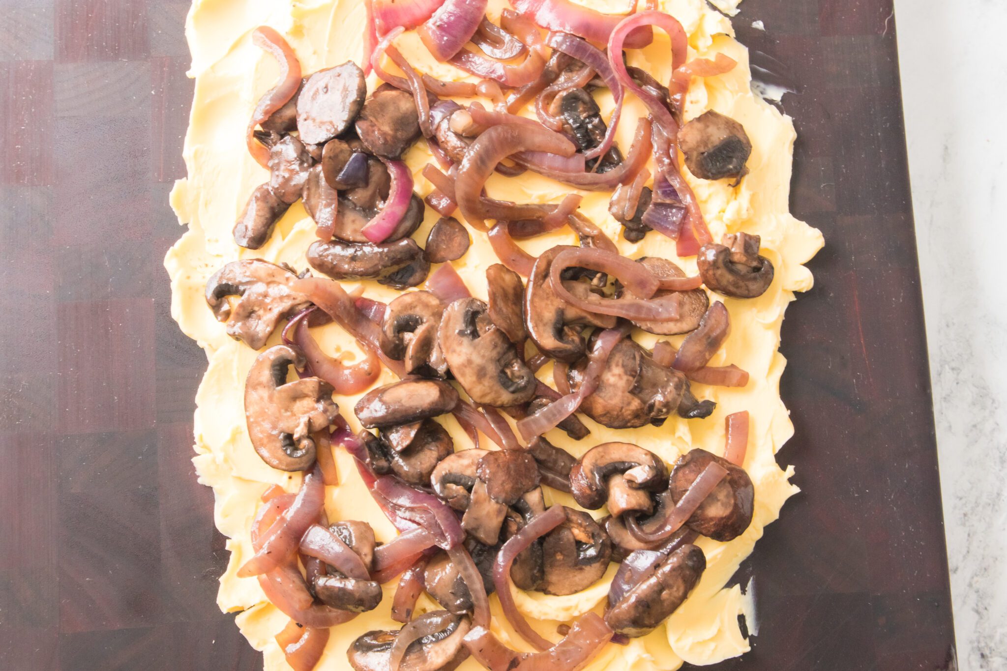 cutting board with butter, onions and mushrooms
