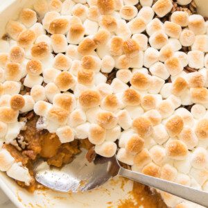 spoon in sweet potato casserole baked with toasted marshmallows