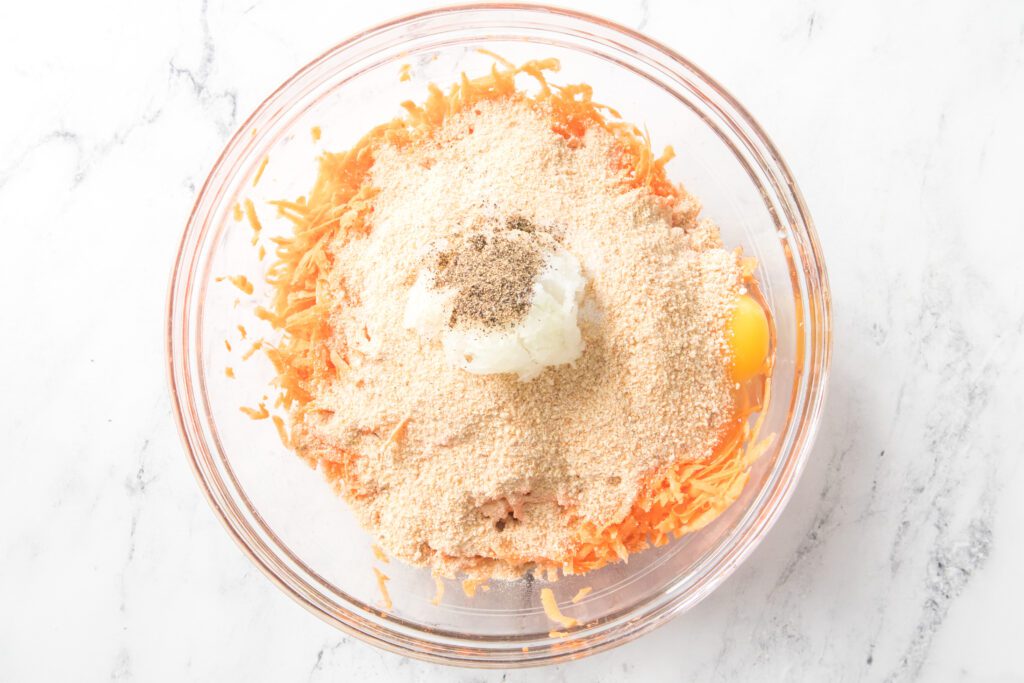 shredded sweet potatoes, eggs, bread crumbs, grated onion and salt and pepper in a glass bowl