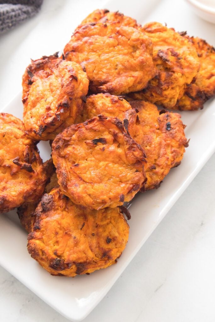 vertical shot of sweet potato latkes on a serving tray