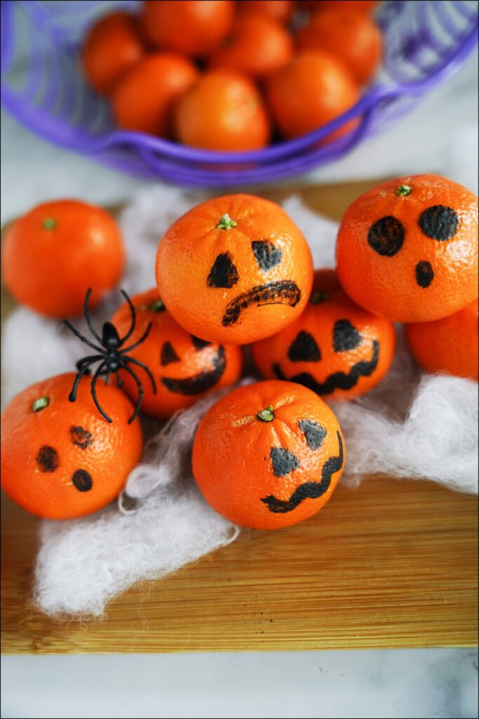 manadarin fruit with ghost and pumpkin faces