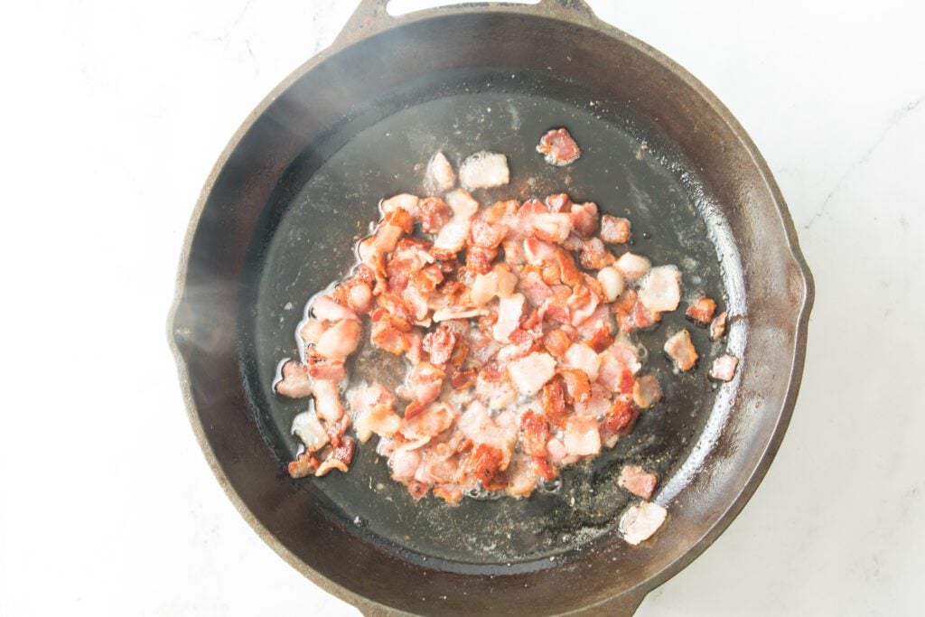 bacon being cooked in cast iron skillet