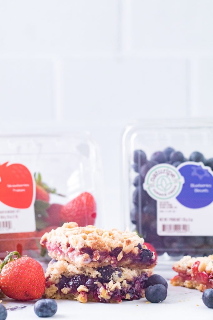 close up vertical shot of mixed berry crumble bar with blueberries and strawberries
