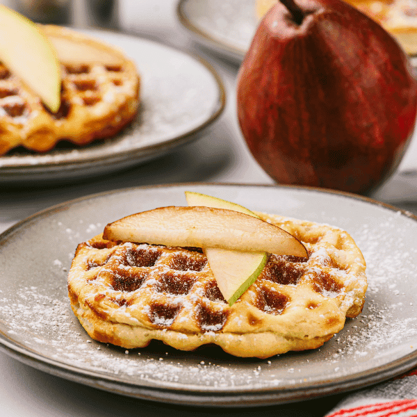 Pear Stuffed Biscuit waffles on plates surrounded by pears