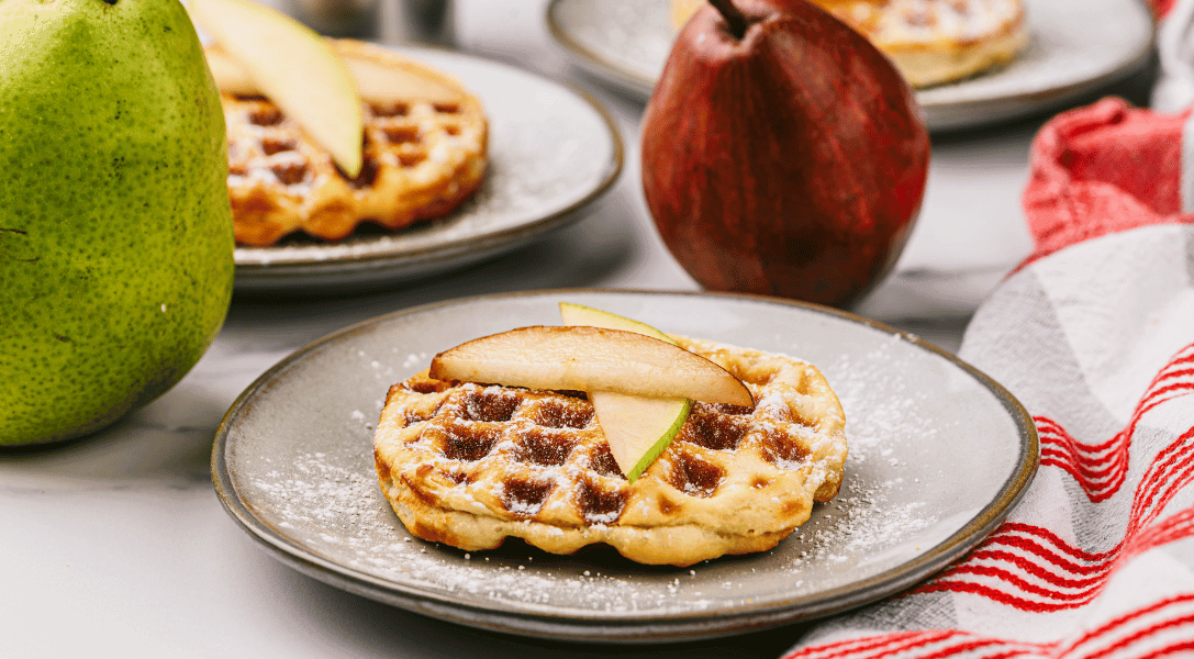Pear Stuffed Biscuit waffles on plates surrounded by pears