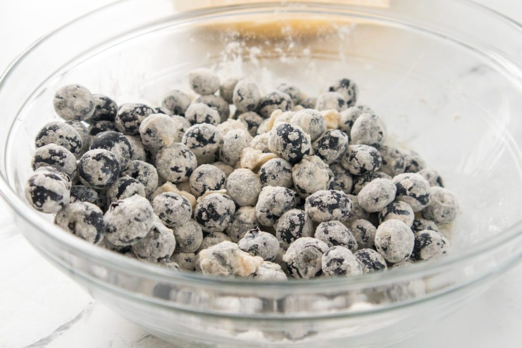 blueberries tossed with flour in a glass bowl
