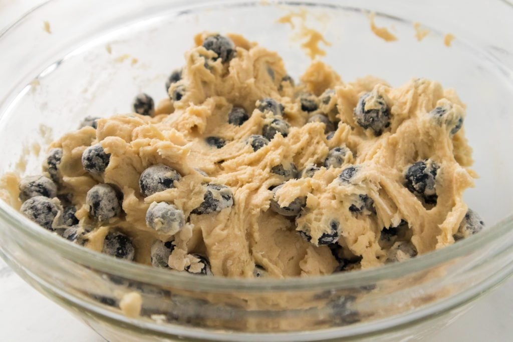 blueberry muffin batter with blueberries in a glass bowl