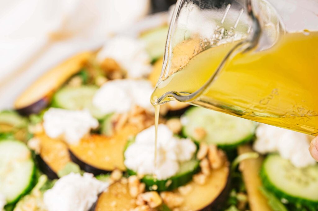 Pouring the dressing over the Plum Ricotta Salad