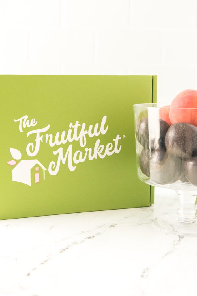 vertical shot of the fruitful market box with fresh fruit in glass dish