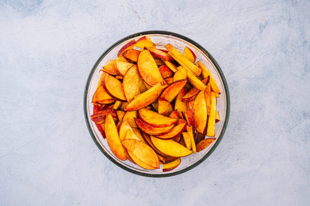 peaches mixed with sugar in bowl