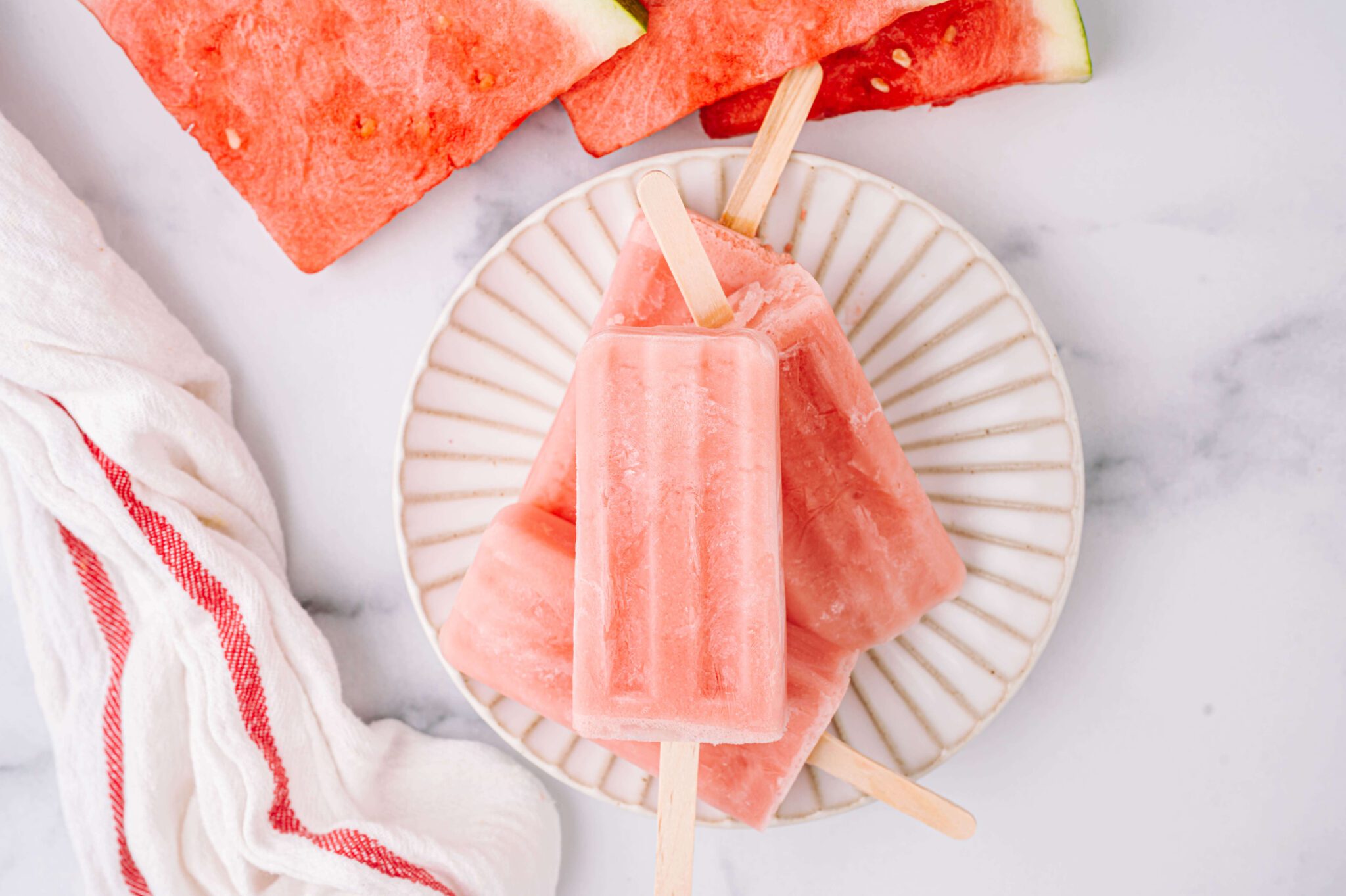 horizontal image of stacked watermelon yogurt pops with watermelon slices