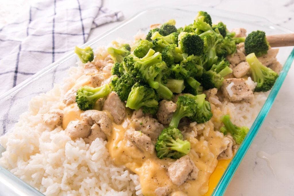 adding rice, chicken and broccoli into a casserole dish