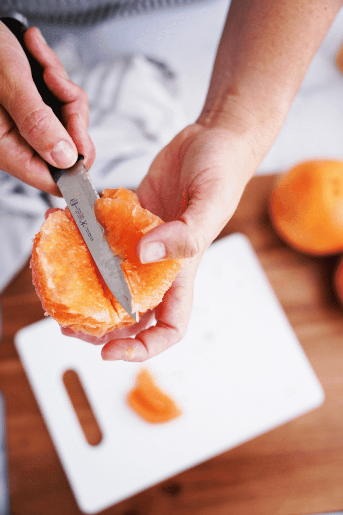 knife in grapefruit over cutting board